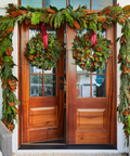 Decorative wreaths and garlands on a wooden door with festive greenery.