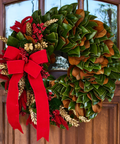 Magnolia Christmas wreath with red bow on a wooden door