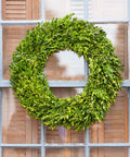Green wreath on a door with wooden shutters