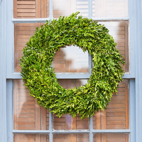 Green wreath on a door with wooden shutters