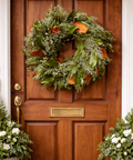fresh greenery wreath hanging on a beautiful wooden door