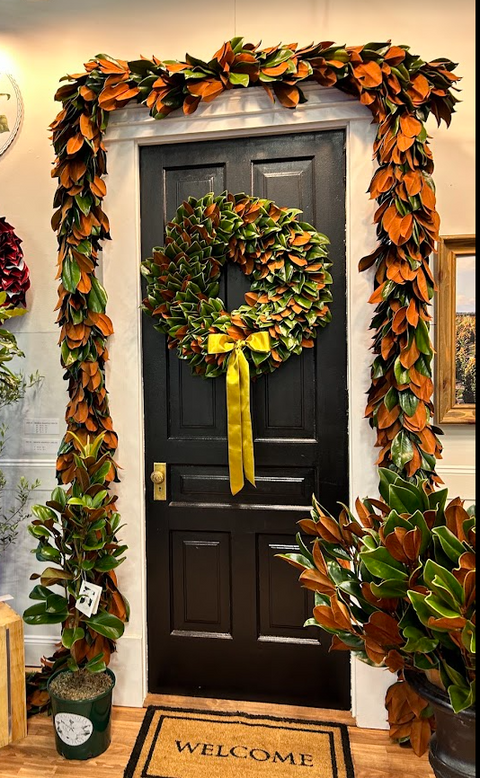 magnolia wreath and garland hanging on a black door