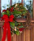 Christmas wreath with red bow on a wooden door