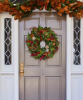 Decorative wreath on a door with autumn-themed garland