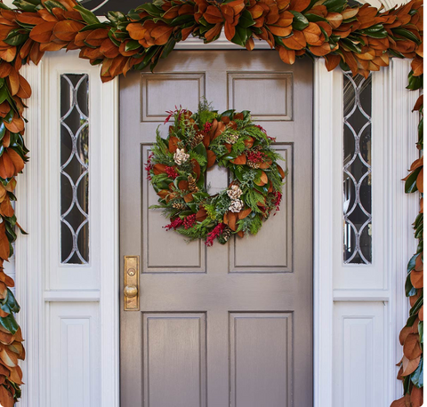 Decorative wreath on a door with autumn-themed garland